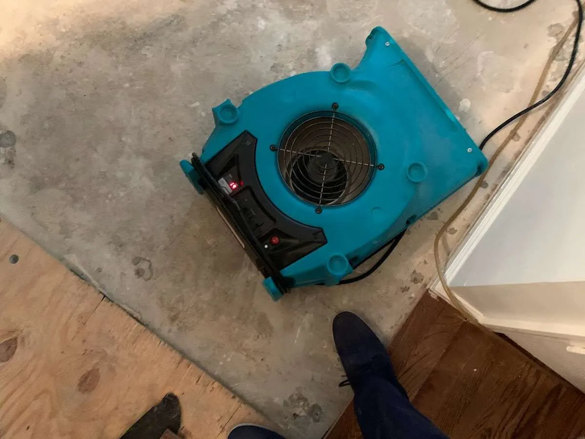 Air mover drying subfloor during Commercial Water Damage Restoration in DeKalb